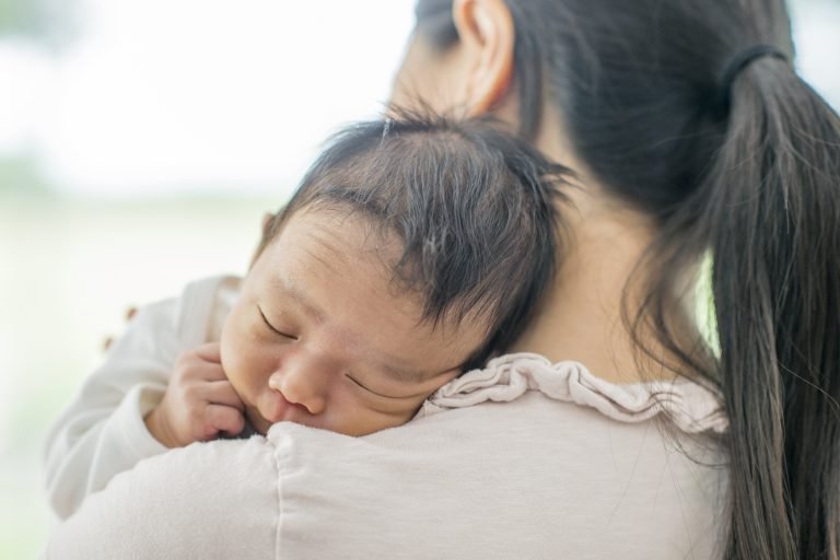 Mother holding baby postpartum (after pregnancy)